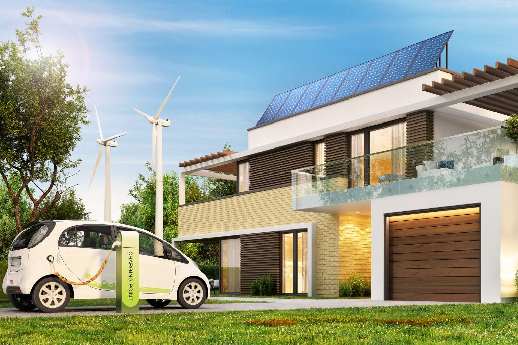 Odnawialne źródła energii obok domu jednorodzinnego wraz z samochodem elektrycznym podczas procesu ładowania